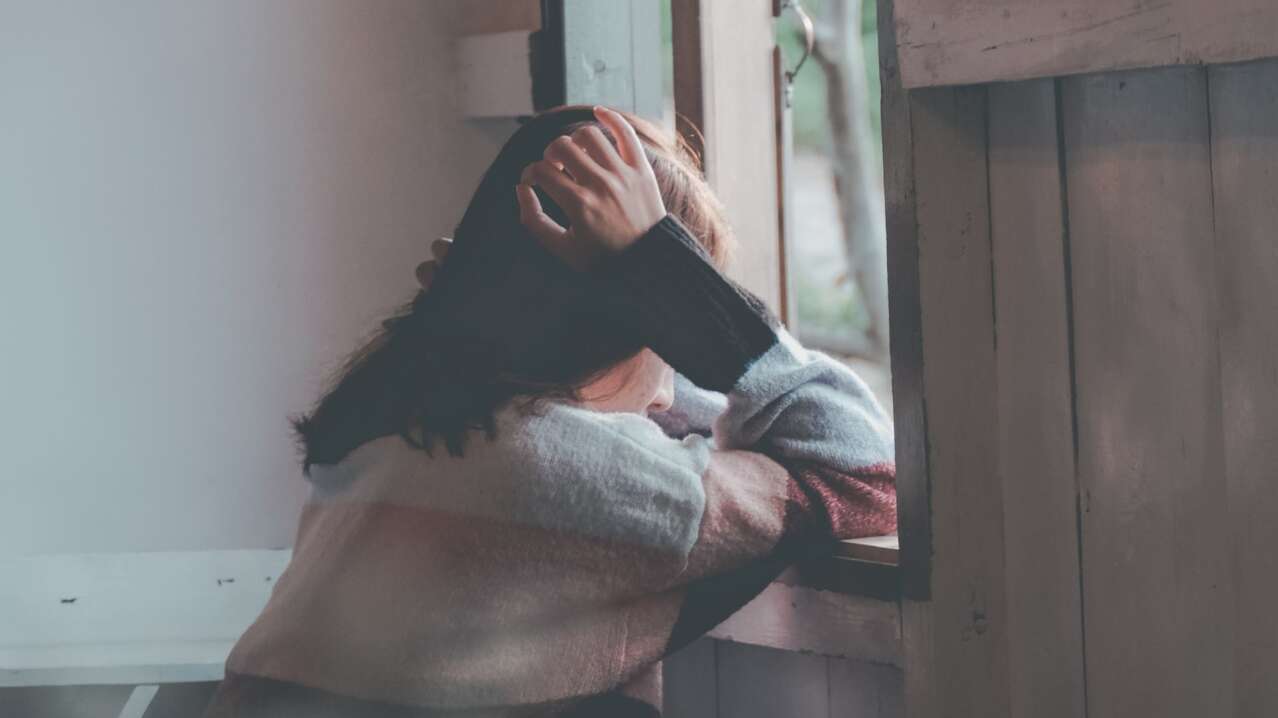 lonely woman looking outside the window