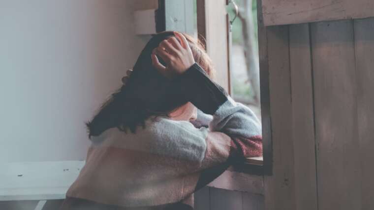 lonely woman looking outside the window