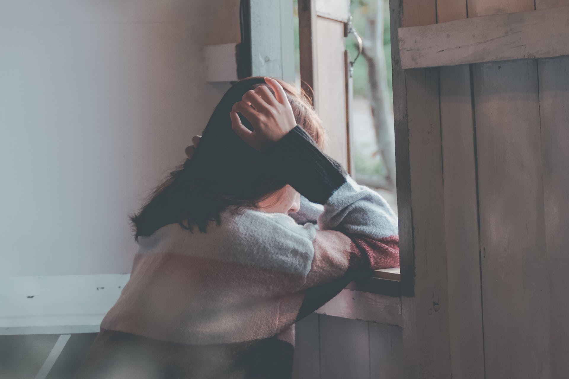 lonely woman looking outside the window