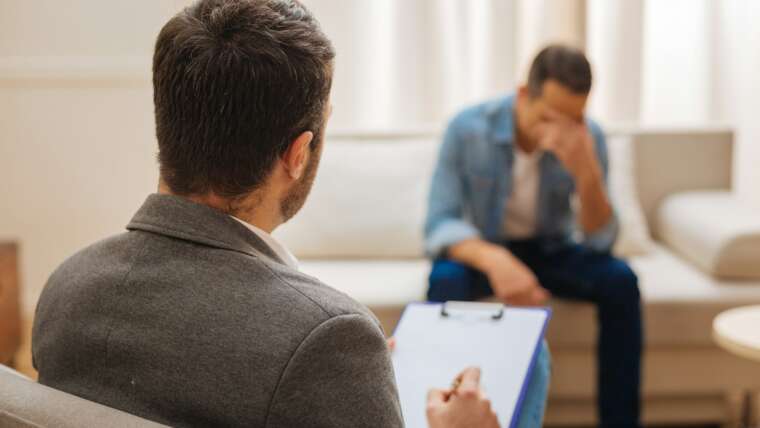 A therapist listens attentively to a distressed client during a counseling session.
