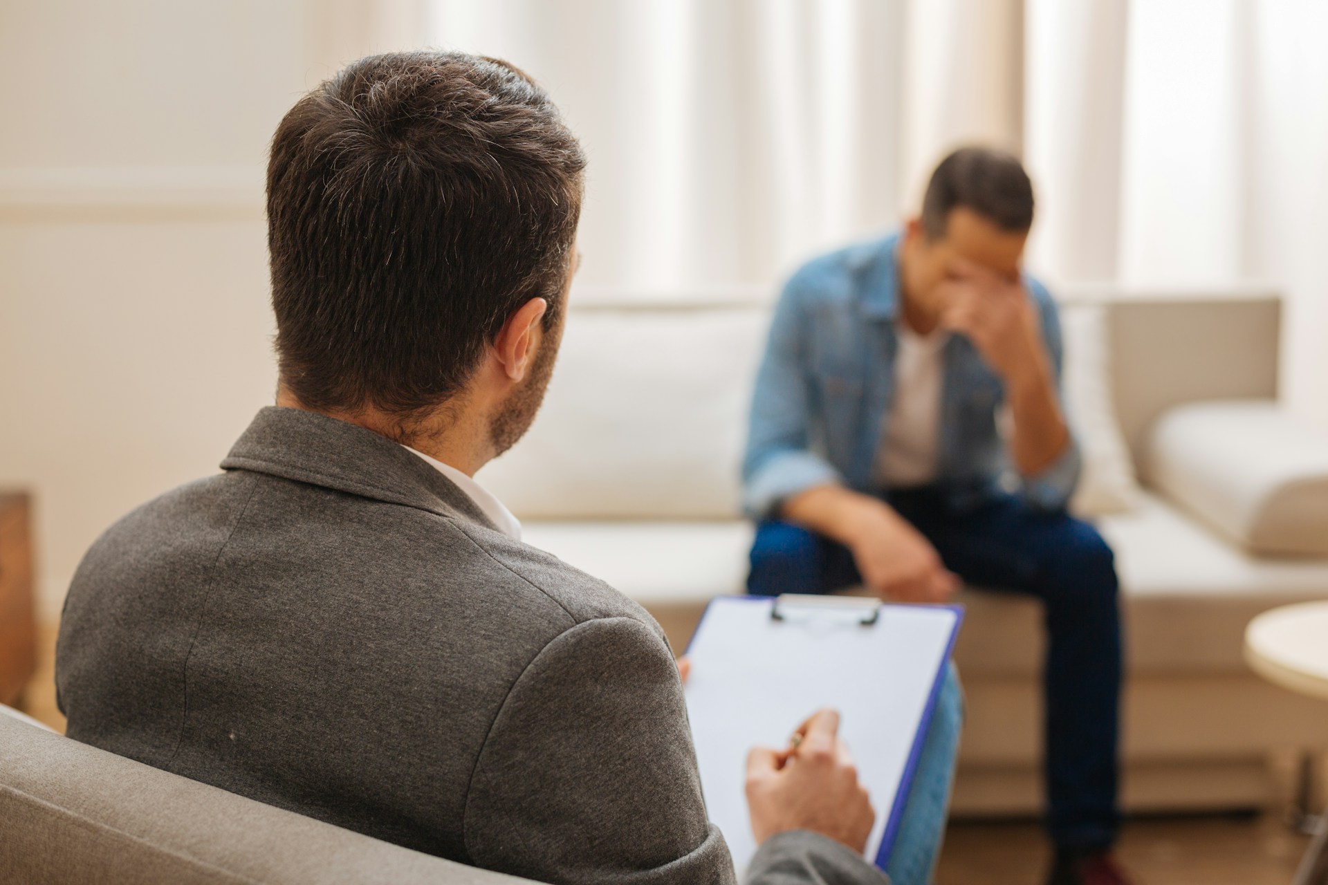 A therapist listens attentively to a distressed client during a counseling session.