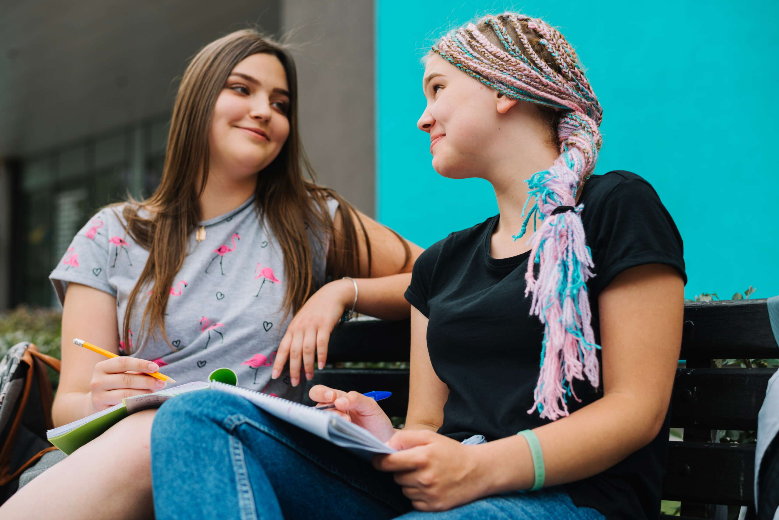 cheerful-students-posing-bench